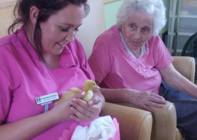 Staff and resident enjoying a baby duckling