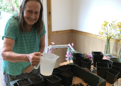A Lulworth House resident potting seeds