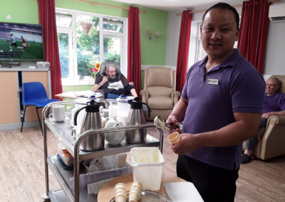 Abbotsleigh Care Home Care Assistant serving ice-creams to residents on a hot day