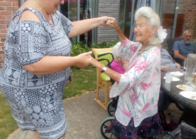 Two ladies dancing at a summer BBQ at Hengist Field Care Home