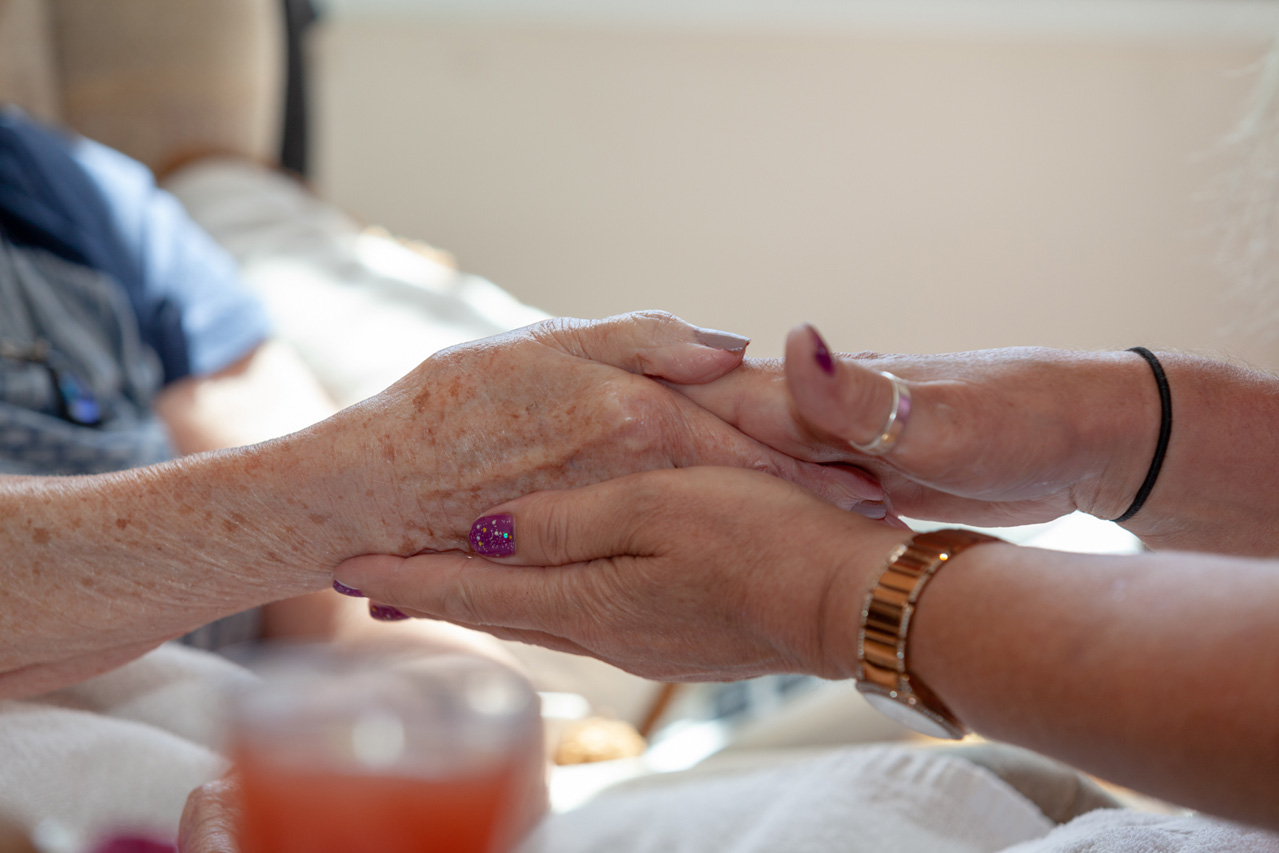 One of our residents receiving an indulgent namaste hand massage, with fresh fruit and chocolate treats
