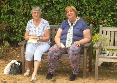 Two seated residents on a garden bench