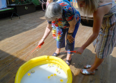 St Winifreds resident and family member playing hook a duck game in paddling pool