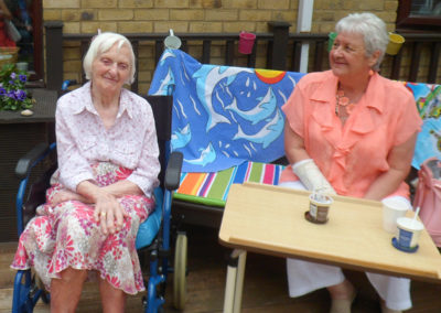 Two female St Winifreds residents enjoying ice-cream on the decking