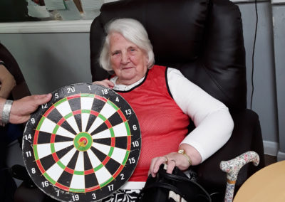 Abbotsleigh resident holding a magnetic dartboard with a dart in the bullseye