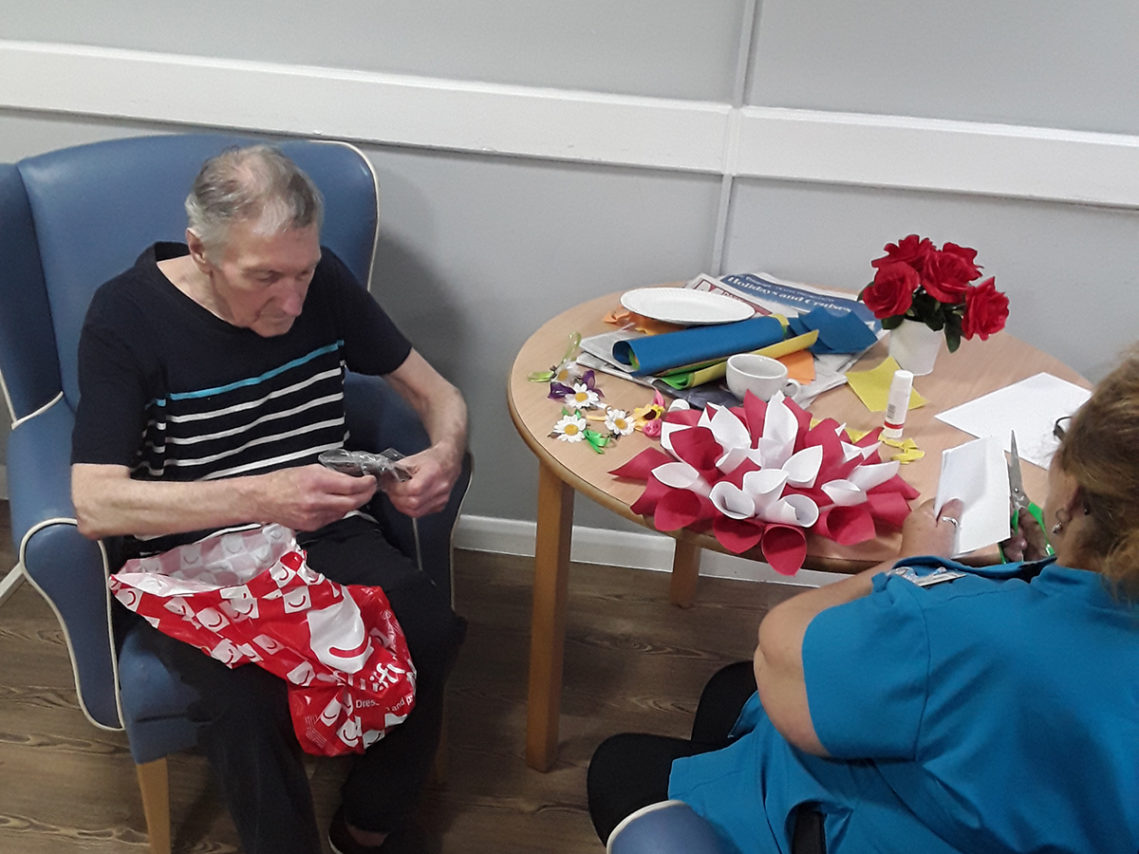 Abbotsleigh resident and staff member making coloured flower decorations using paper