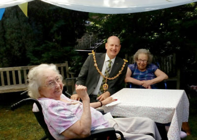 Two female residents at Loose Valley chatting with Councillor David Naghi in the garden