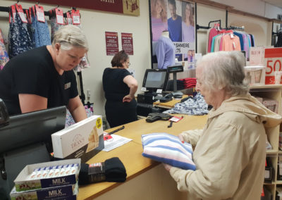 Lukestone Care Home resident paying for a jumper at the counter in Notcutts Garden Centre