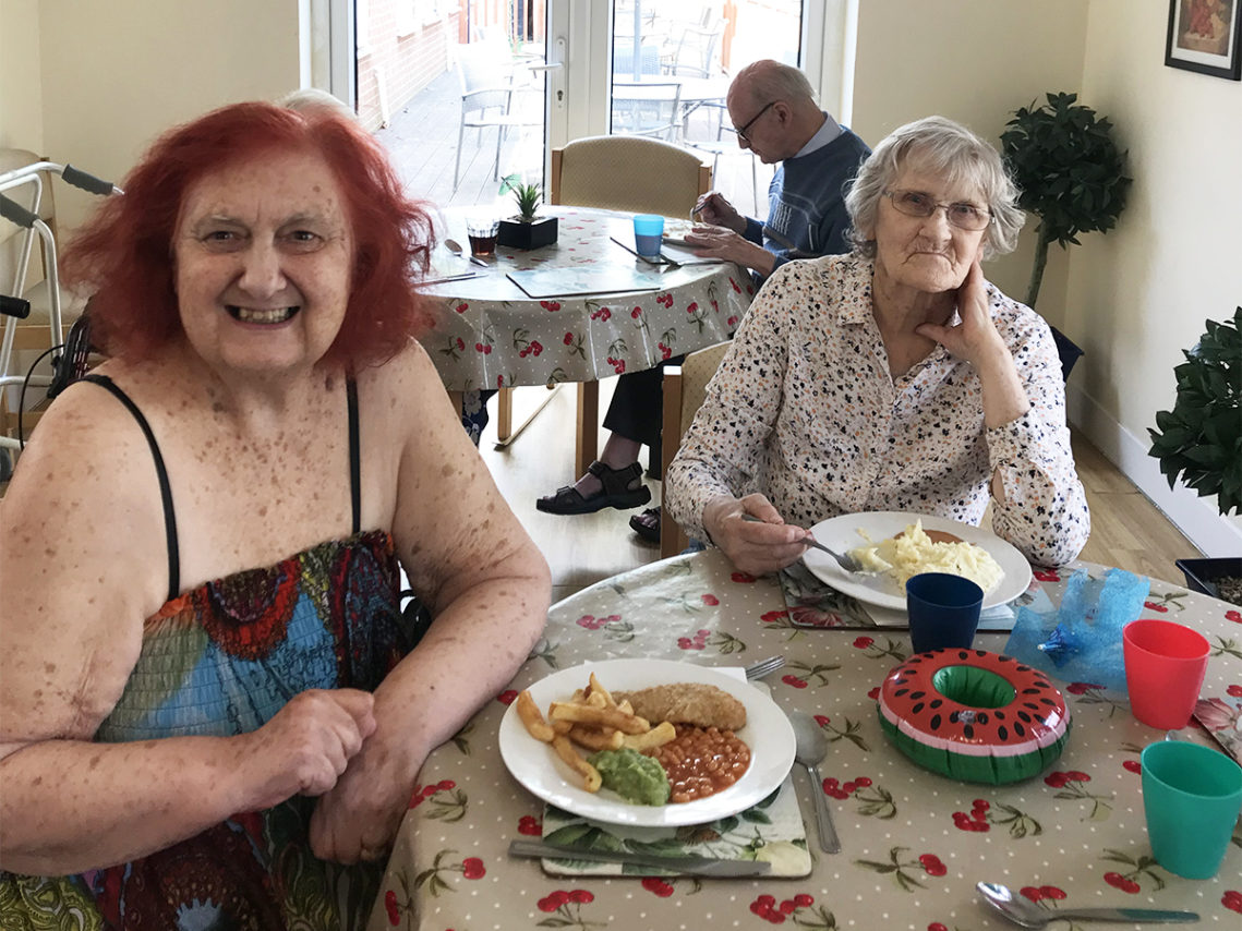 Residents seated in their dining room enjoying a seaside-themed lunch