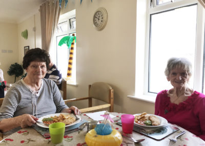 Residents seated in their dining room enjoying a seaside-themed lunch