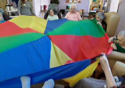 Princess Christian residents playing parachute games while seated in a circle