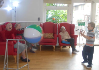A resident and visiting child playing beach ball games together