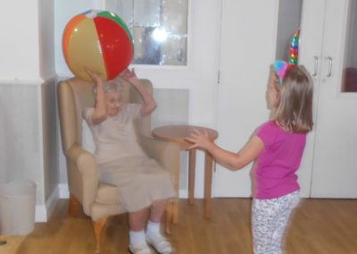 Woodstock Residential Care Home resident playing beachball catch with a young girl