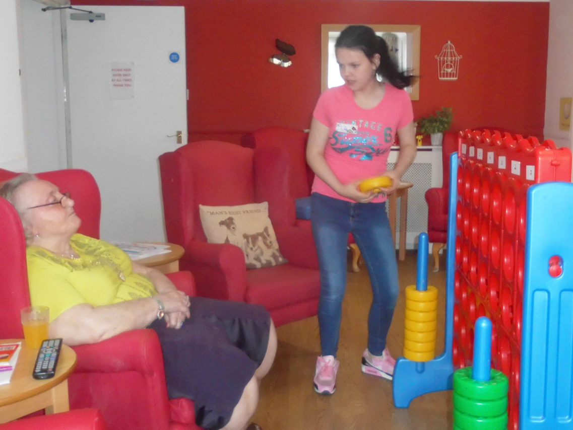 A resident and visiting child playing giant Connect Four together