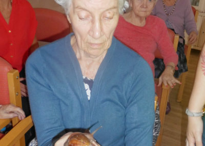Female resident at Woodstock holding a giant snail from a mobile mini zoo in her hand