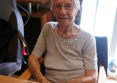 Hengist Field Care Home resident smiling to camera with her homemade mini-quiches in front of her