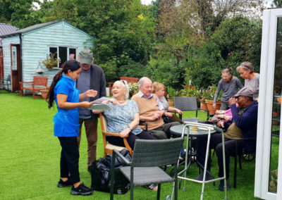 A group of residents and visitors enjoying the garden at Lukestone Care Home