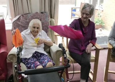Residents at Lulworth House waving colourful scarves as part of an active armchair exercise session