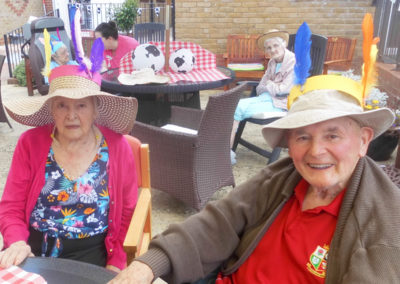 Residents enjoying a summer BBQ, wearing fancy dress hats