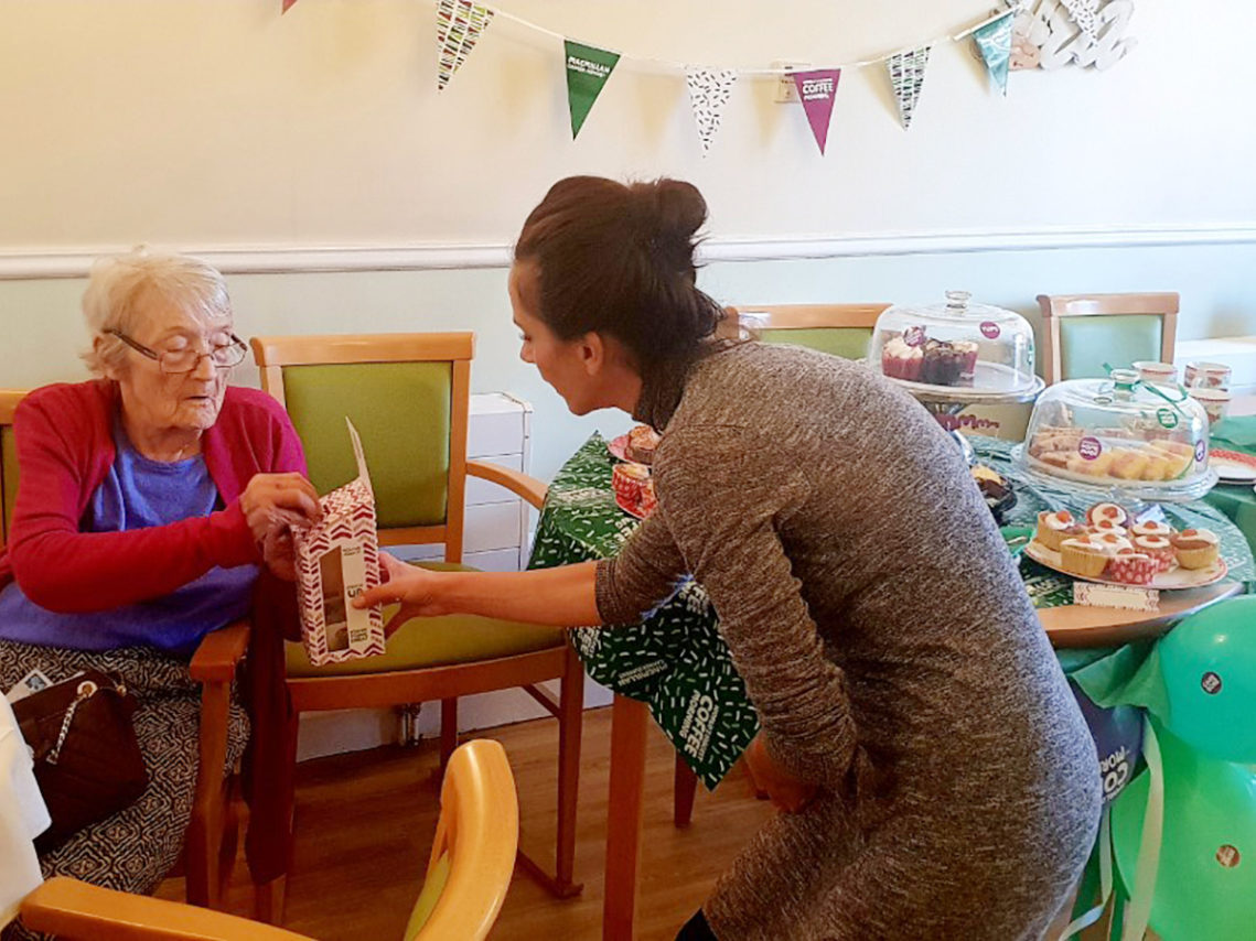 Lukestone staff member serving cakes and tea to residents during their Macmillan coffee morning