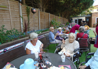 Residents, family and friends at Lulworth House enjoying a summer BBQ in the garden
