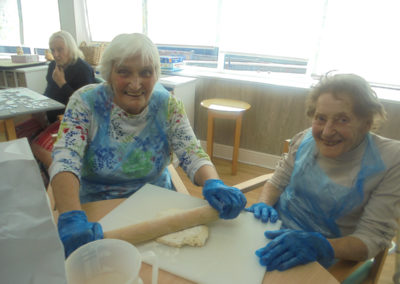 Two ladies at The Old Downs Residential Care Home rolling out pastry for jam tarts