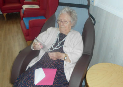 Lady resident at Woodstock Residential Care Home opening birthday cards
