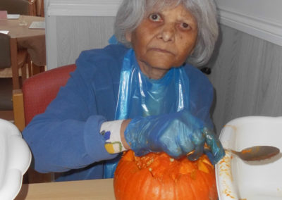A residents carving her pumpkin at Woodstock Residential Care Home
