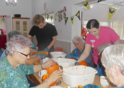 Residents enjoying getting messy carving pumpkins at Woodstock Residential Care Home