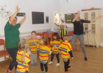 Squirrel Lodge Nursery dancing with staff members at Woodstock Residential Care Home