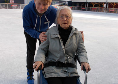 Lady resident and carer on the ice at Ruxley Manor Garden Centre's ice rink
