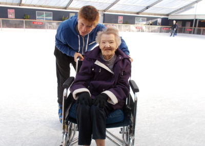 A lady resident and carer on the ice at Ruxley Manor Garden Centre's fun ice rink