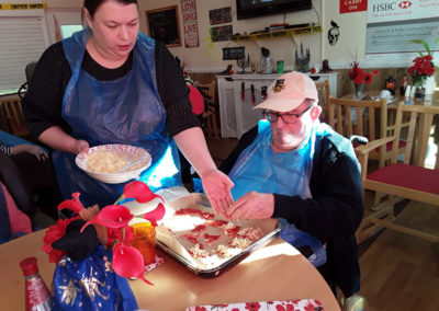 Meyer House residents topping witch hat shaped pizza bases
