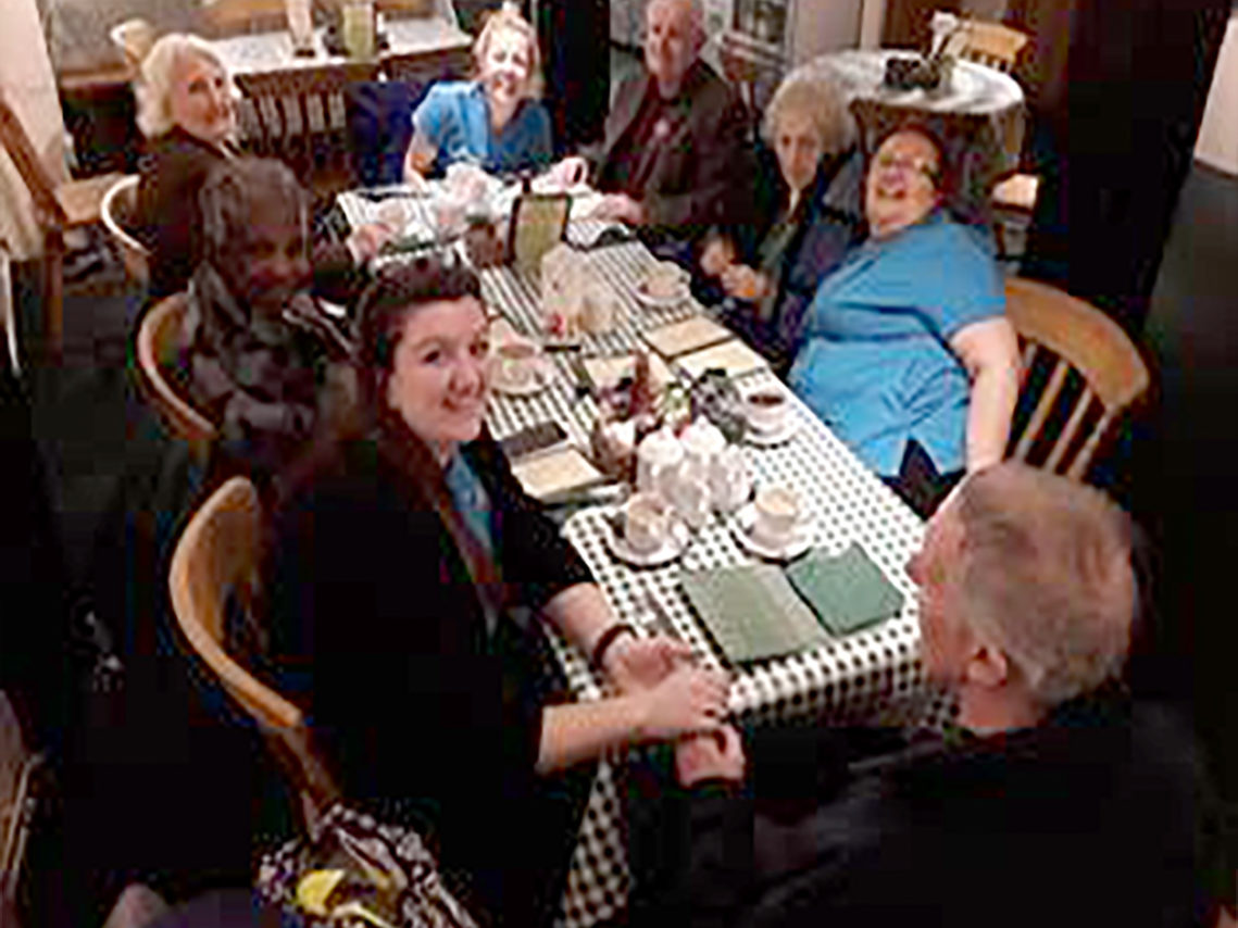 Abbotsleigh Care Home residents and staff sitting around a table in a tea room