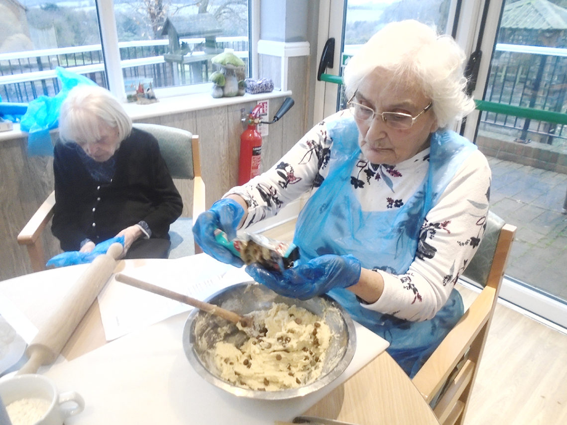 Lady resident at The Old Downs Residential Care Home, preparing cookie ingredients in a bowl