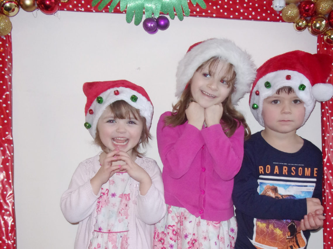 Three young children in Santa hats at the Loose Valley Christmas party