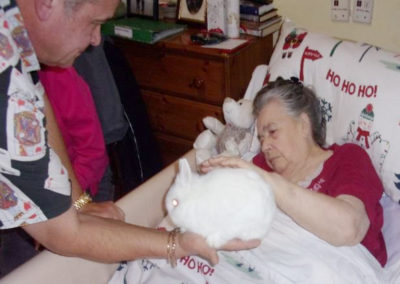 Mark the magician showing a white rabbit to a resident in her room at Loose Valley Care Home