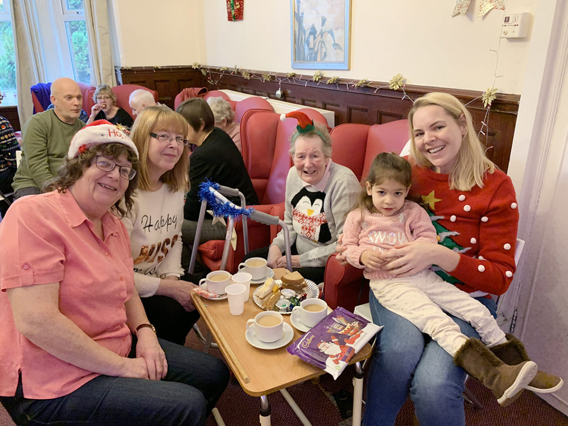 A resident and her family posing for a photo together at Lulworth House Residential Care Home