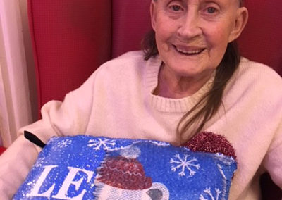 Lulworth House lady resident with a Christmas cushion