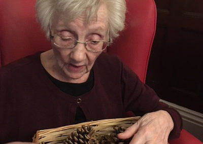 Lulworth House lady resident feeling fir cones in a box