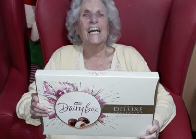 A Lulworth House residents smiling at receiving a large box of chocolates