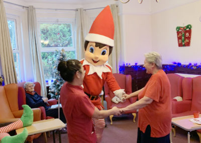 Staff and residents enjoying a dance with the giant elf at Lulworth House