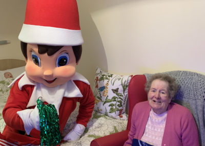 A resident posing for a photo with the giant elf at Lulworth House