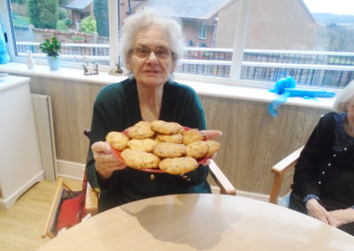 Lady resident at The Old Downs Residential Care Home, holding a plate of homemade cookies