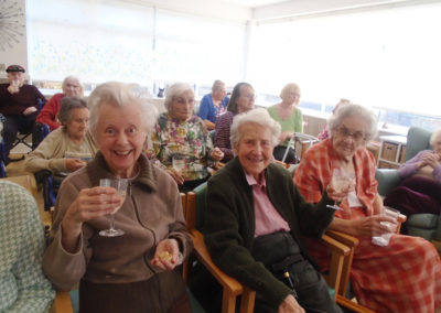 The Old Downs residents enjoying a sherry and a mince pie while listening to Reverend Jim