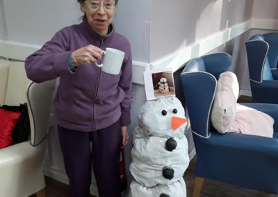 Abbotsleigh Care Home resident standing next to a large snowman decoration