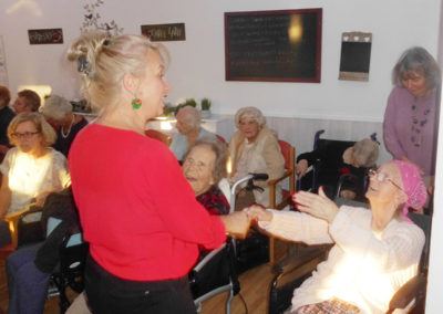 Woodstock Residential Care Home resident dancing in her chair at the Christmas party