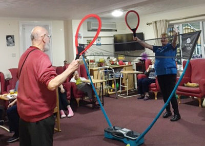 Male resident at Lulworth House playing indoor badminton