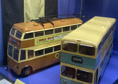 Two vintage model buses in a cabinet at Maidstone Museum