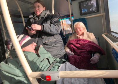 Residents and staff sitting on a bus together
